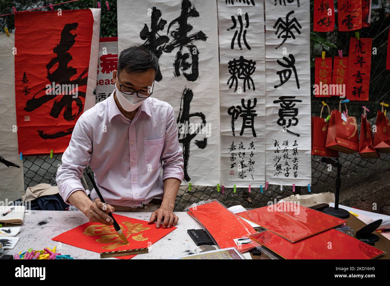 On January 24, 2022, Hong Kong, on the eve of Chinese New Year in Hong Kong, some calligraphers write lucky messages on the street. (Photo by Leung Man Hei/NurPhoto) Stock Photo