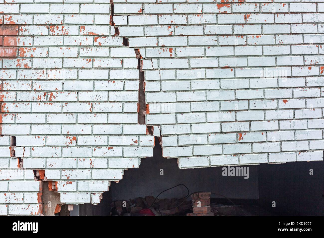 Building exterior brick wall with extreme damage cracks holding up from