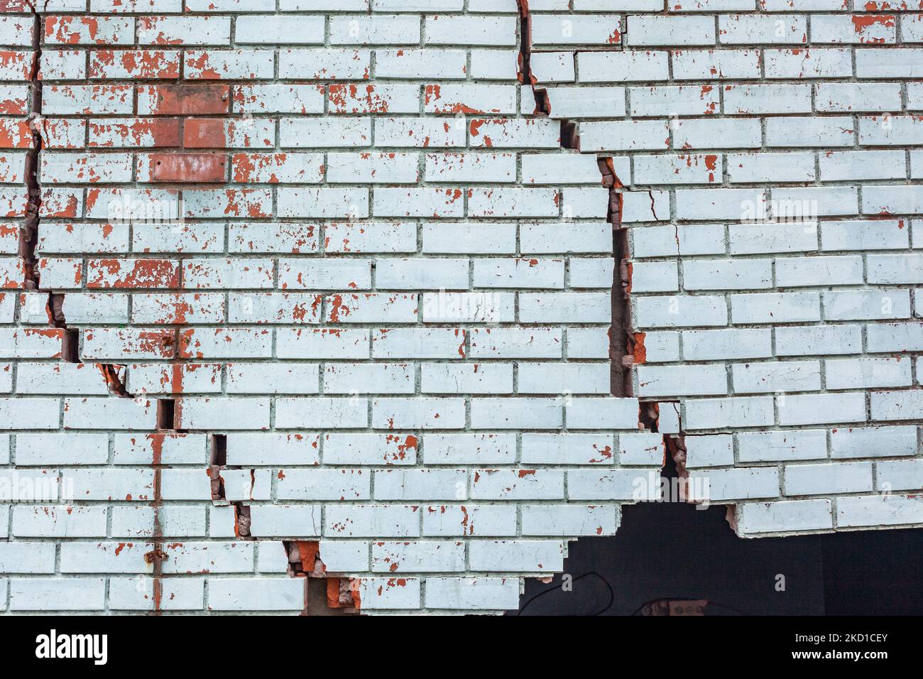 Building exterior brick wall with extreme damage cracks holding up from