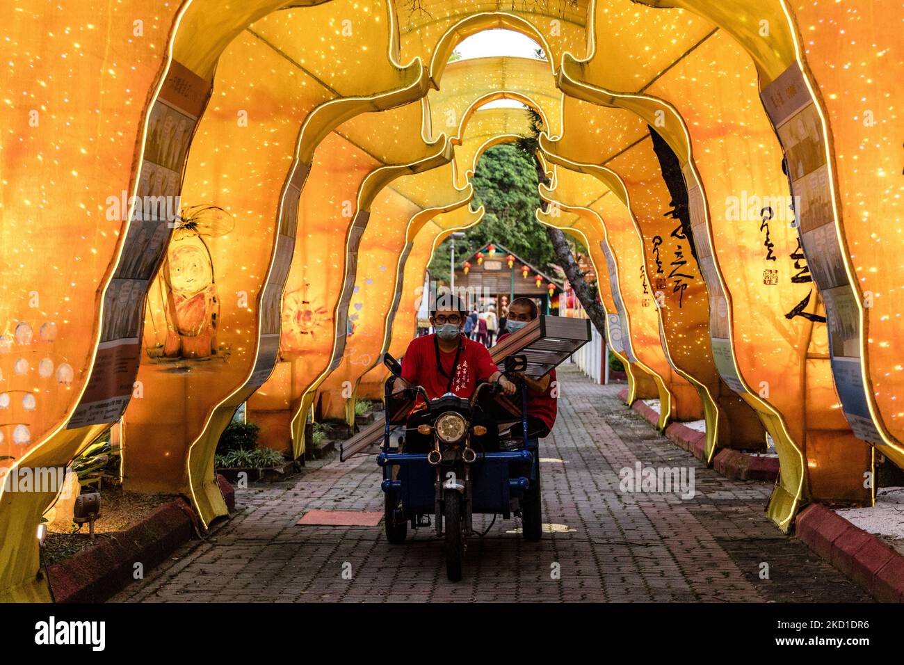 Workers ride through the Chinese New Year decorations at the Fo Guang Shan Dong Zen Temple ahead of the upcoming Lunar New Year of the Tiger on January 28, 2022 in Jenjarom outside Kuala Lumpur, Malaysia. (Photo by Mohd Firdaus/NurPhoto) Stock Photo