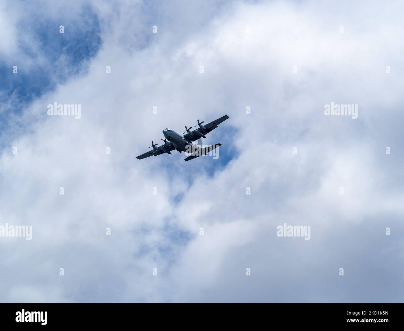 A Japanese self defense force C-130 airplane flying above Naval Air Facility Atsugi before landing Stock Photo