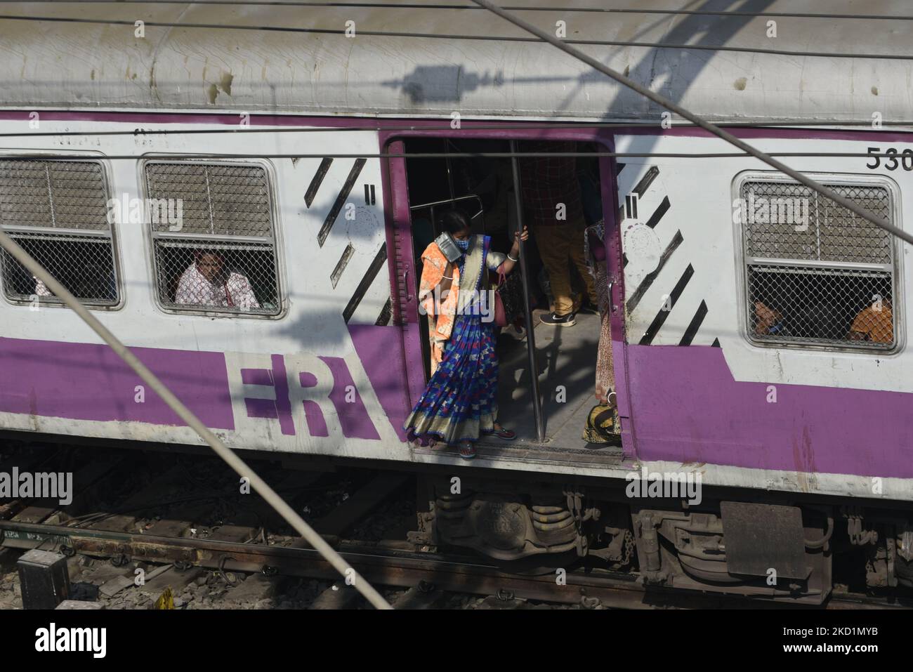 A passenger stands on a footboard of a local train in Kolkata, India