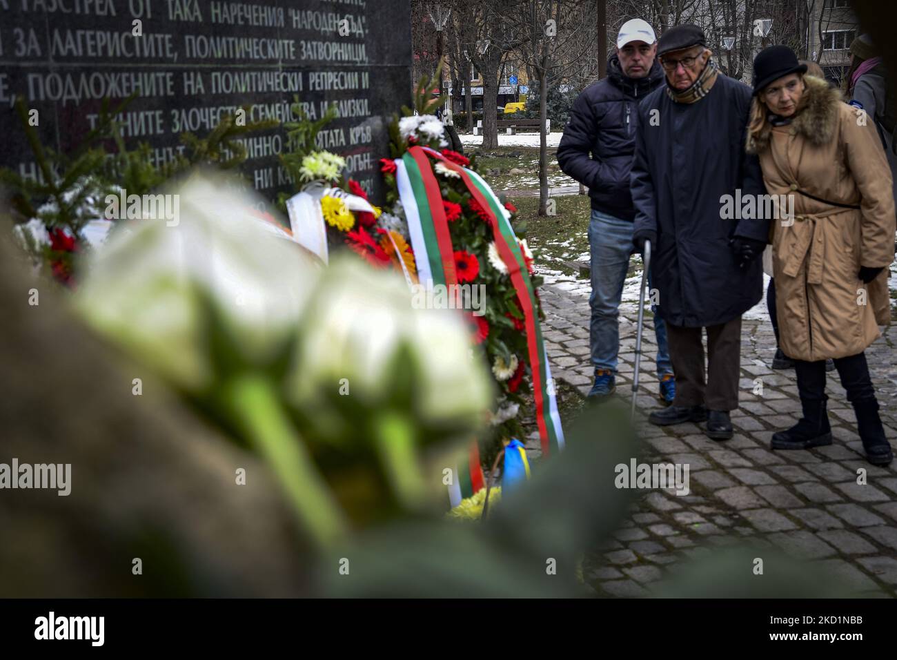 People pay tribute in front of memorial monument with the names of ...