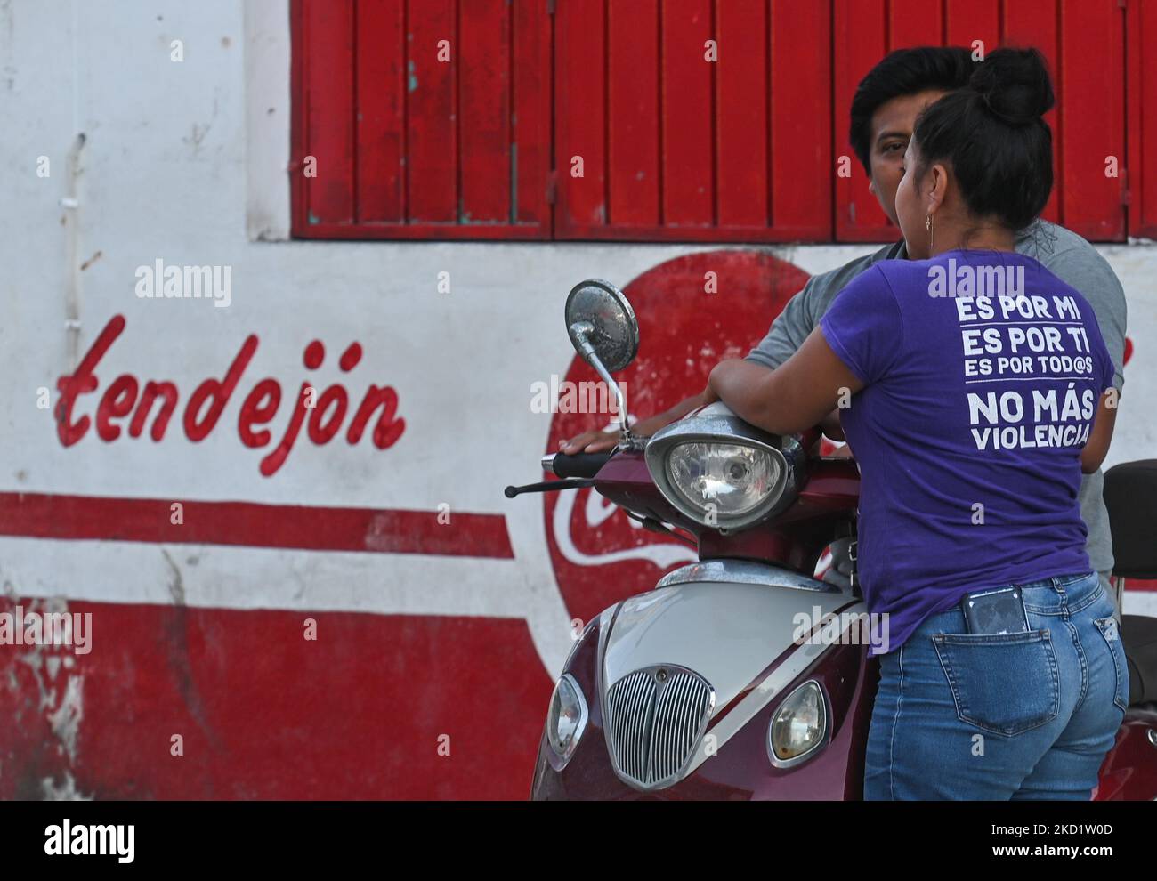 A woman wearing a t-shirt with words 'It's for me, it's for you, it's for everyone. No more violence' chating to a local man. On Thursday, February 03, 2022, in Celestun, Yucatan, Mexico. (Photo by Artur Widak/NurPhoto) Stock Photo