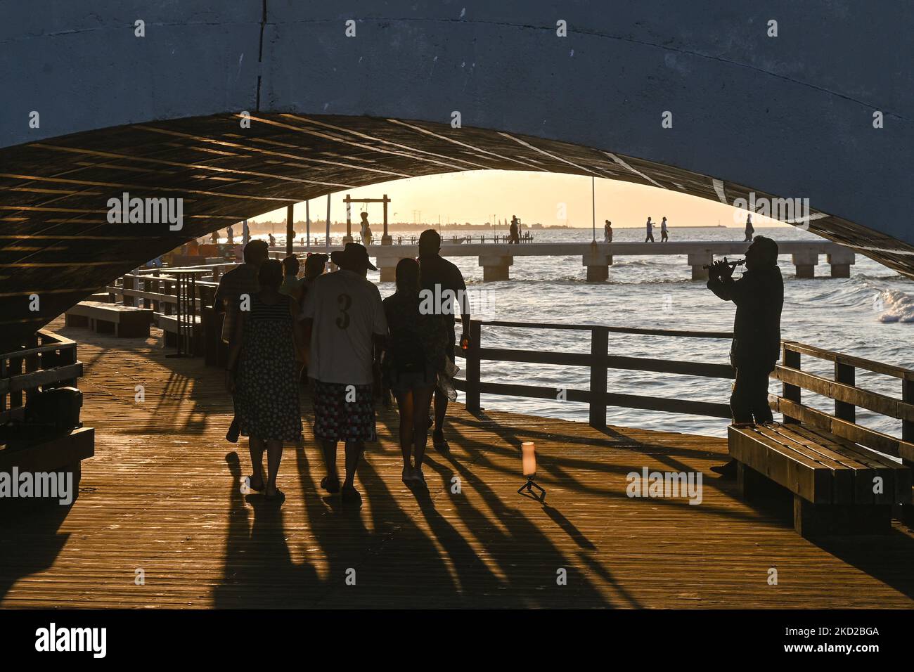 VIsitors walk under bridge next to the beach in Progreso. On Wednesday