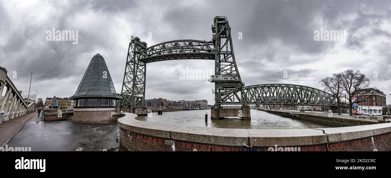 Panoramic wide angle view of the iconic historic De Hef - Koningshavenbrug Bridge in the Dutch port city of Rotterdam may be dismantled for Jeff Bezos superyacht to pass under, as the mast of the sailboat exceeds the height of the bridge. The two-tower with swing lift bridge is an old level steel railroad bridge connecting the island, Noordereiland in the Maas river in the Southern part of Rotterdam. The bridge was built in 1877 and suffered damage during the 1940 German bombings. Since 2017 after the renovation work, the municipality promised that the bridge would never be dismantled again. T Stock Photo