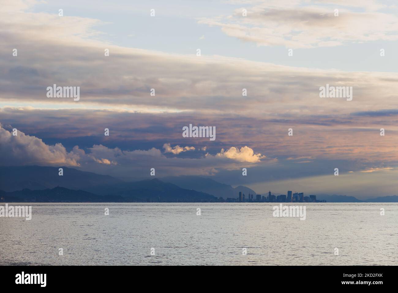 Panorama of a modern city in the distance against the backdrop of the sea, mountains, sunset time. Batumi, Georgia Stock Photo