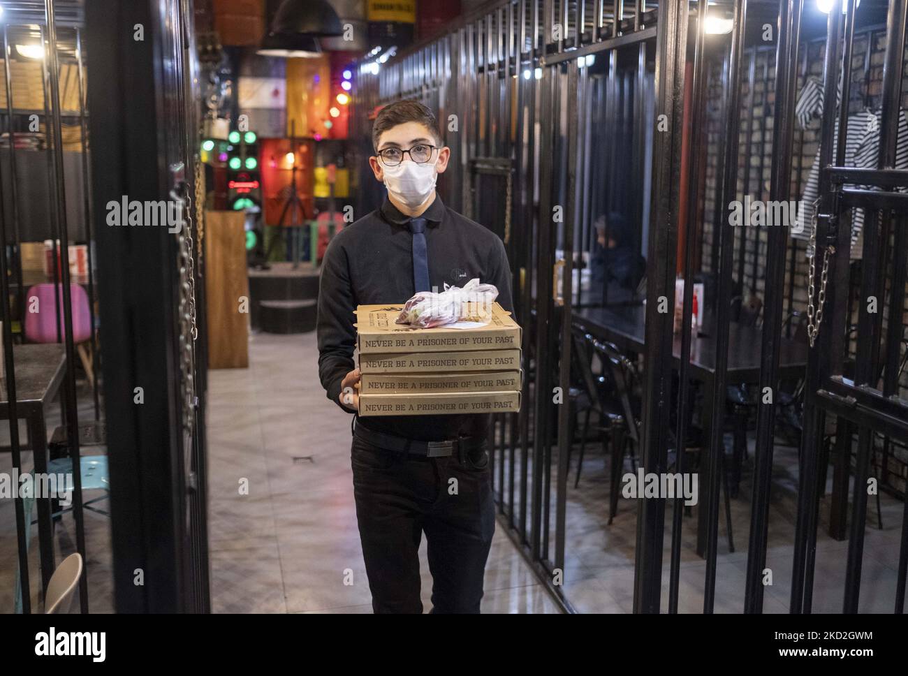 Waiter Box An Iranian waiter carries pizza container boxes while walking along a ...