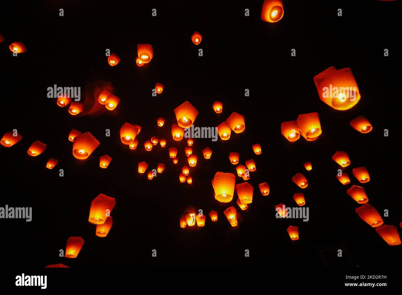 People take pictures as lanterns are lit to colour the sky with people