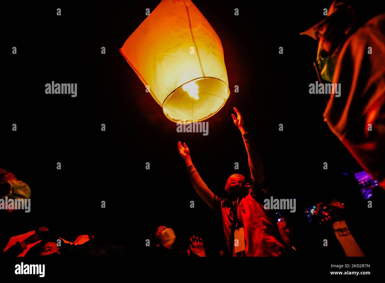 People take pictures as lanterns are lit to colour the sky with people’s wishes for luck, blessings, healthy and prosperity, during the annual Pingxi Sky Lantern Festival, in Pingxi Area of New Taipei, Taiwan, 15 February 2022. Lantern Festival has been a significant convention celebrated amongst Chinese speaking regions across Asia including Taiwan, Hong Kong and Mainland China, according to the lunar calendar, with Taiwanese people releasing paper lanterns brimming with wishes and desires including safety and stability. (Photo by Ceng Shou Yi/NurPhoto) Stock Photo