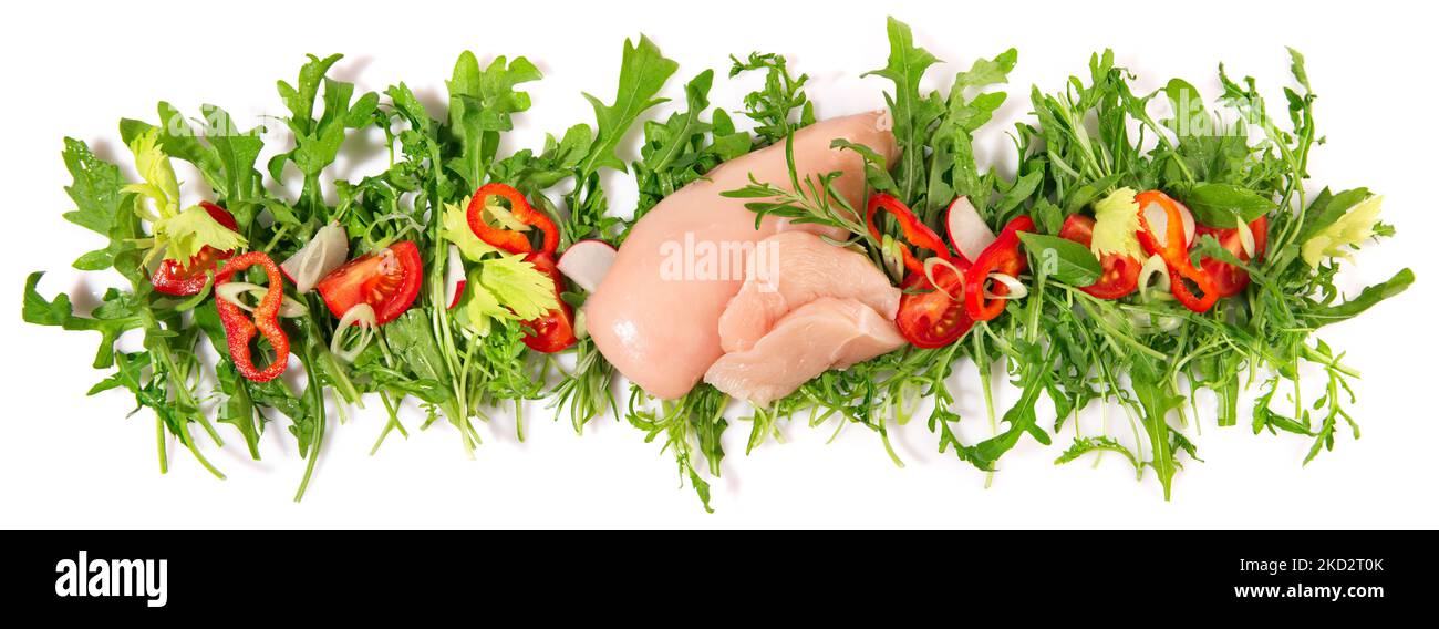 Raw Chicken Breast with fresh Rocket Salad Panorama isolated on white Background Stock Photo