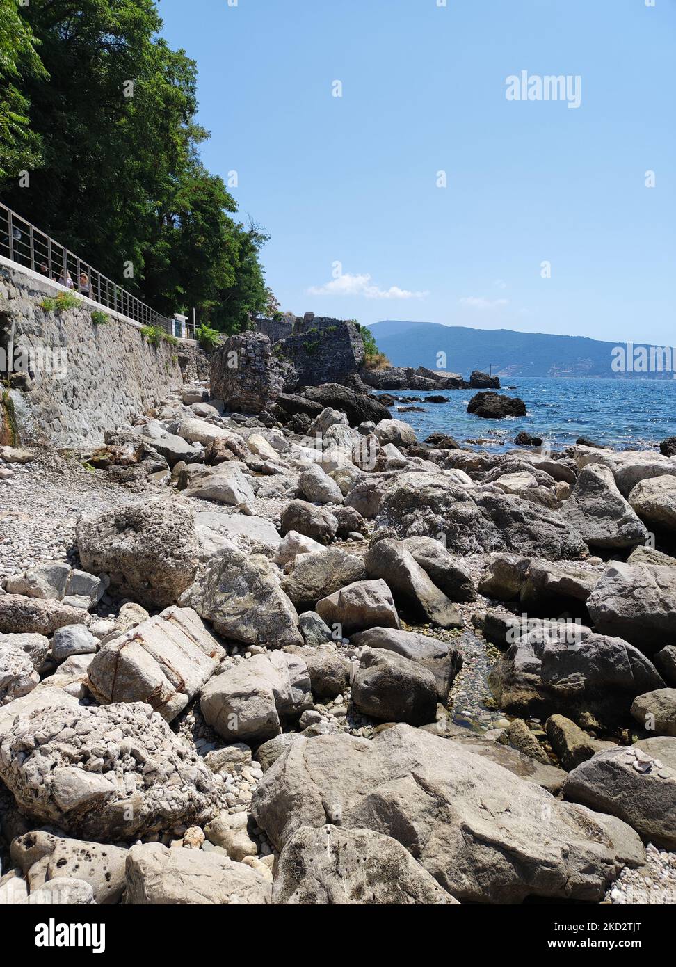 A vertical shot of the rocky shore and blue sea. Montenegro Stock Photo ...