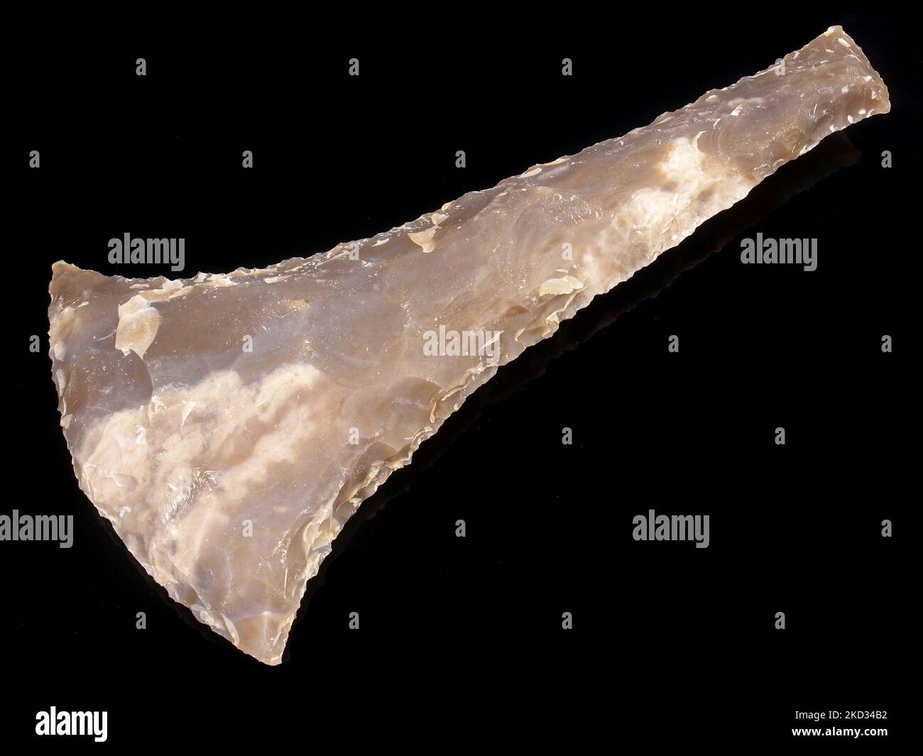 Stone Age Axe Head out of Flintstone on black Background Stock Photo