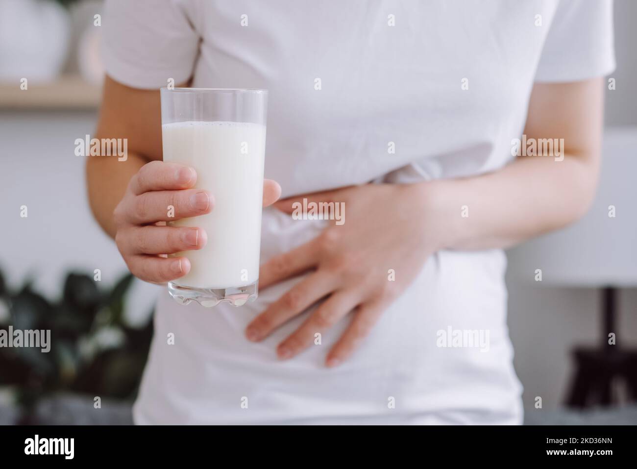 Close up of unrecognizable unhealthy young woman holding glass of milk