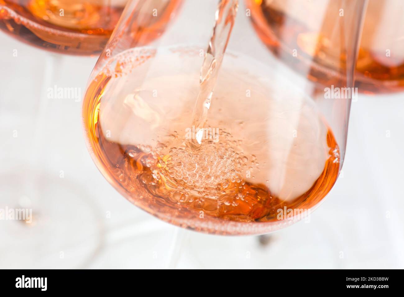 Pouring rose wine in a glass in front of white background Stock Photo ...