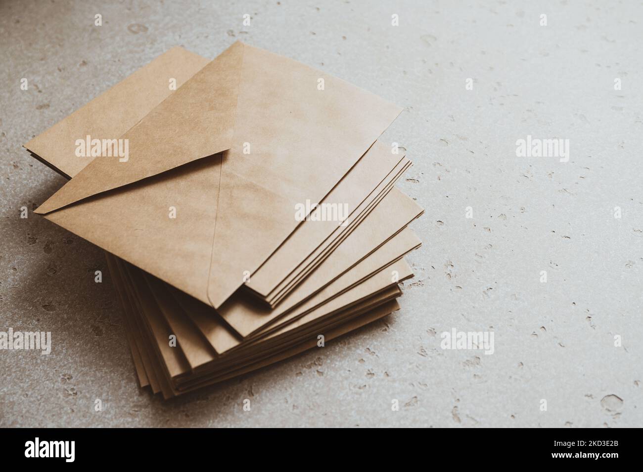 A stack of craft paper envelopes on a table. Stock Photo