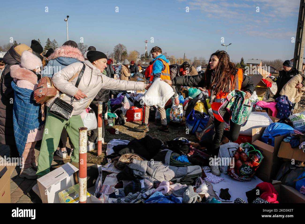A volunteer gives away a blanket to Ukrainian woman after arriving to Poland as tens of