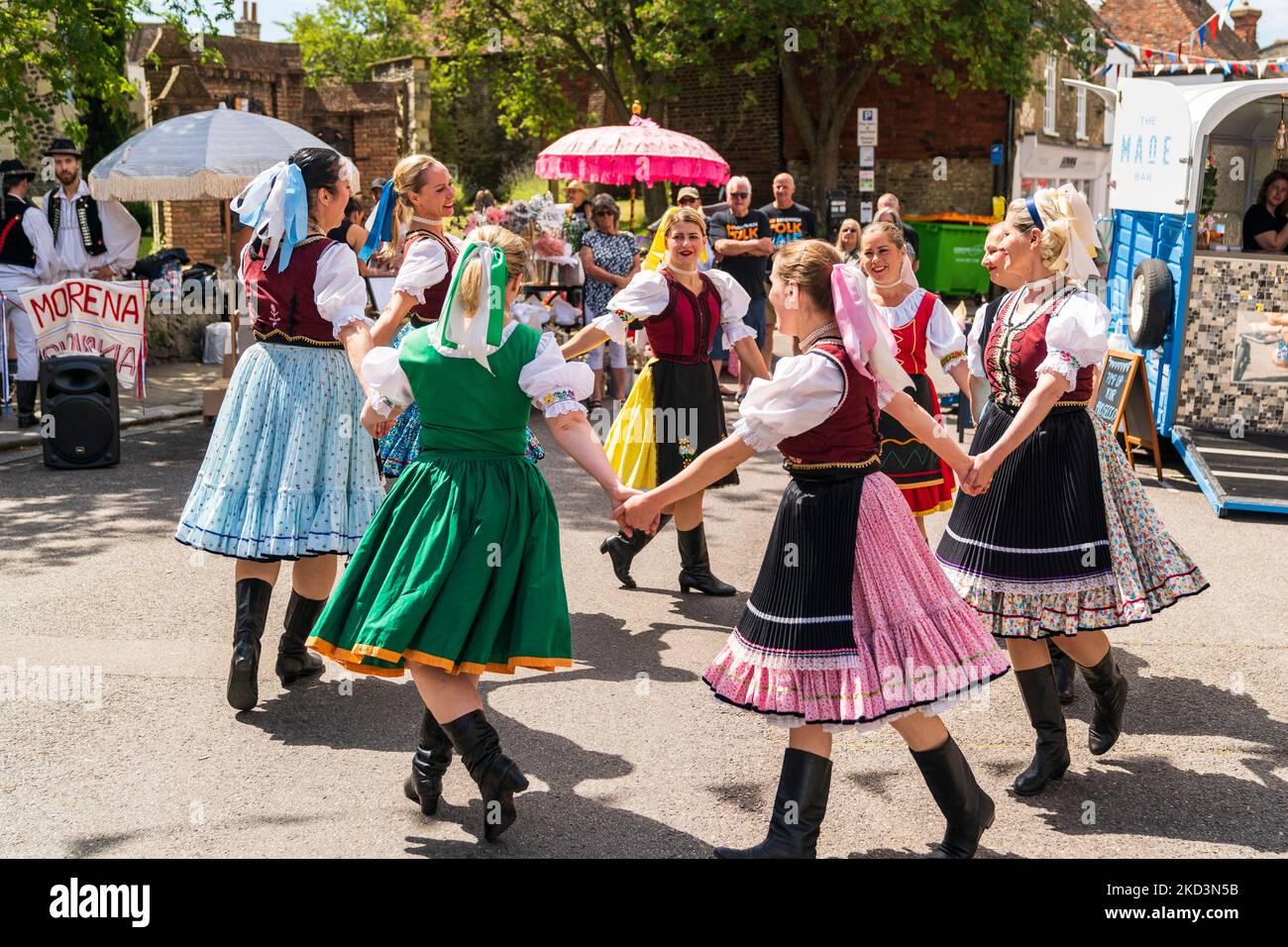 Bulgarian folk dancers in traditional costume dancing on the street at an event in the English medieval town of Sandwich in the summer. Stock Photo