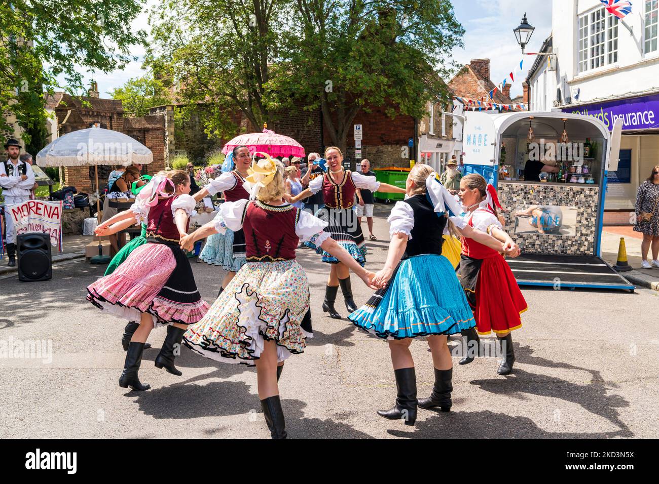 Bulgarian folk dancers in traditional costume dancing on the street at an event in the English medieval town of Sandwich in the summer. Stock Photo