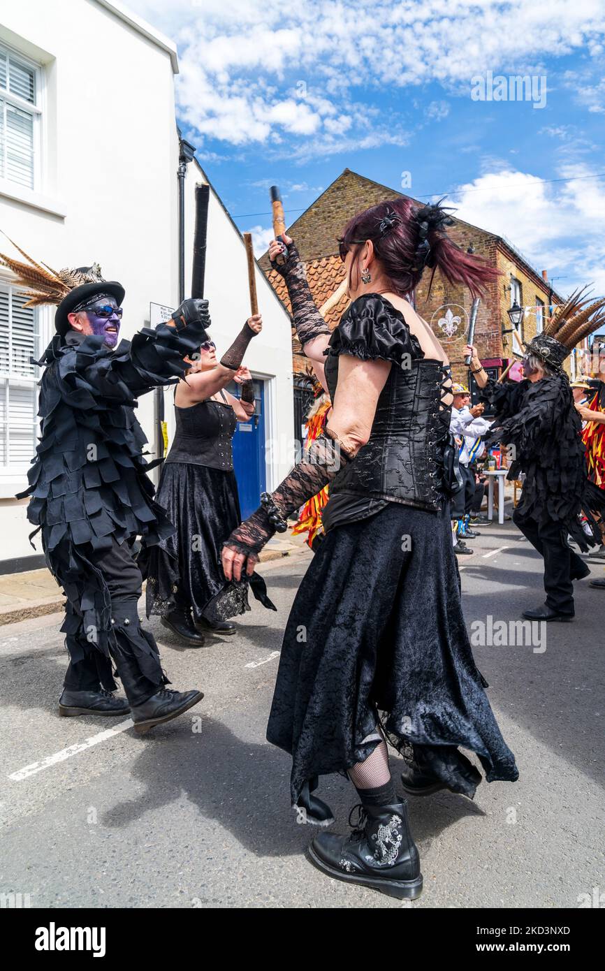 Traditional folk Morris dancers, the Wolf Head Morris side, dancing in the streets of the historical medieval town of Sandwich in Kent in the summer. Stock Photo