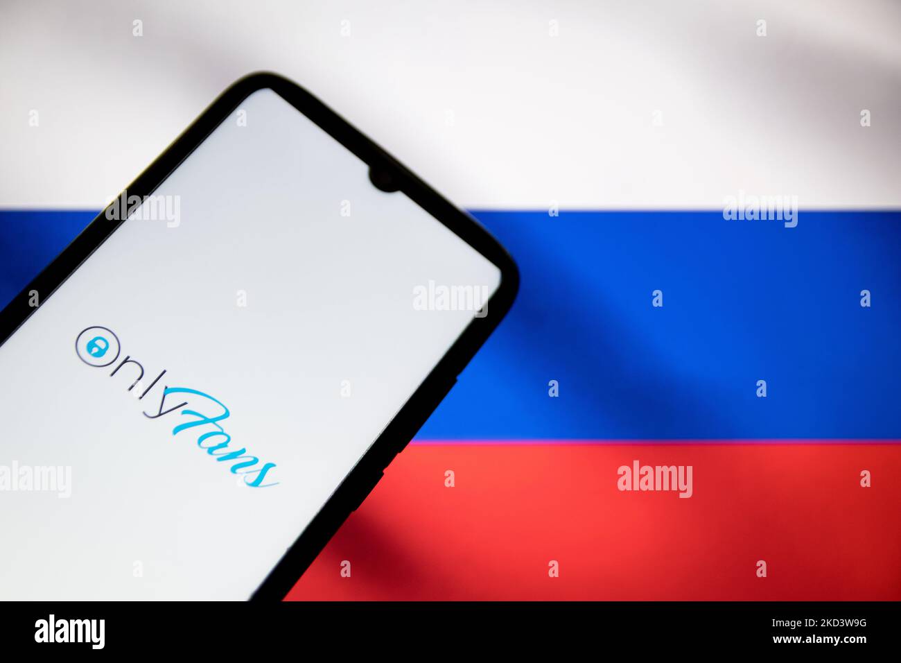In this photo illustration an OnlyFans logo seen displayed on a smartphone screen with a flag of Russia in the background in Athens, Greece on February 28, 2022. (Photo illustration by Nikolas Kokovlis/NurPhoto) Stock Photo