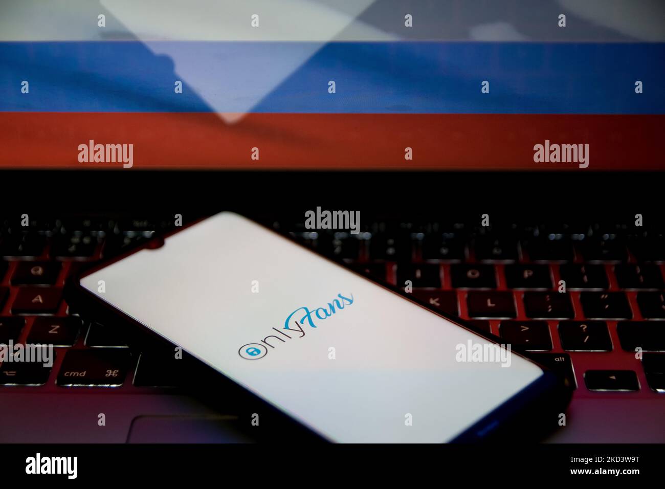 In this photo illustration an OnlyFans logo seen displayed on a smartphone screen with a flag of Russia in the background in Athens, Greece on February 28, 2022. (Photo illustration by Nikolas Kokovlis/NurPhoto) Stock Photo