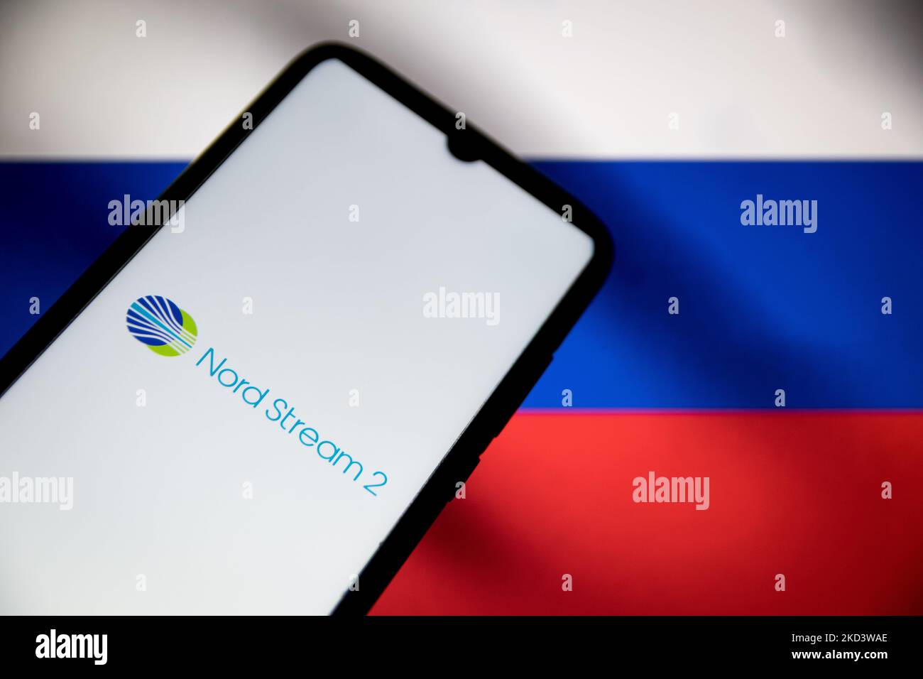 In this photo illustration a North Steam 2 logo seen displayed on a smartphone screen with a flag of Russia in the background in Athens, Greece on February 28, 2022. (Photo illustration by Nikolas Kokovlis/NurPhoto) Stock Photo