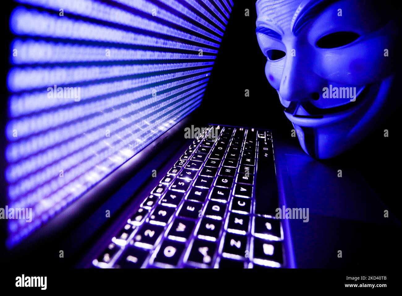 Binary code displayed on a laptop screen and Guy Fawkes mask are seen in this illustration photo taken in Krakow, Poland on March 1, 2022. Global hacker group Anonymous declared 'cyber war' against Russia. (Photo by Jakub Porzycki/NurPhoto) Stock Photo