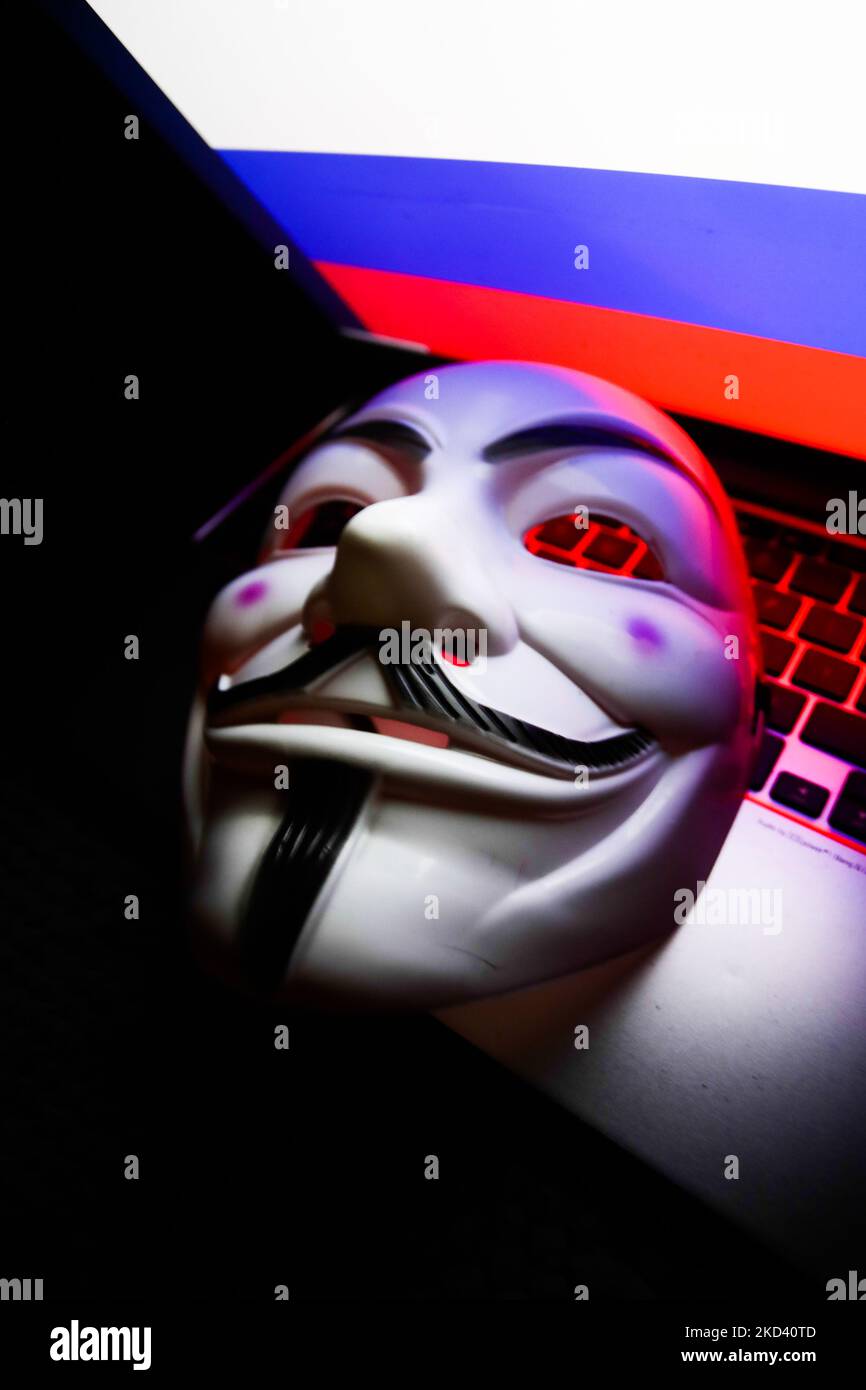 Russian flag displayed on a laptop screen and Guy Fawkes mask are seen in this illustration photo taken in Krakow, Poland on March 1, 2022. Global hacker group Anonymous declared 'cyber war' against Russia. (Photo by Jakub Porzycki/NurPhoto) Stock Photo