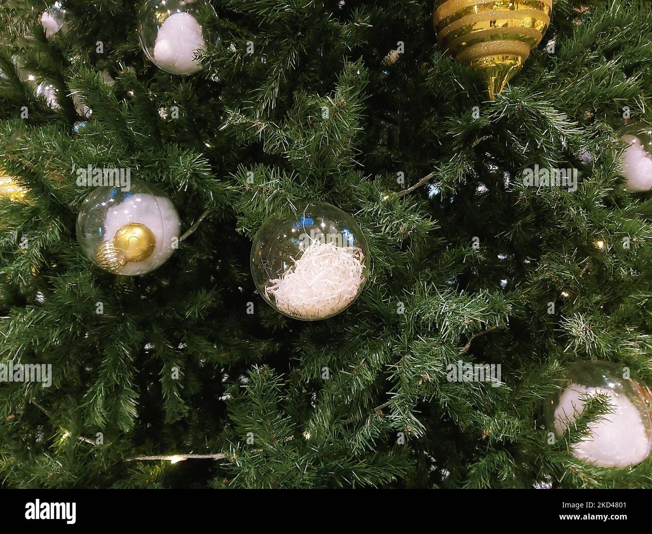 Variety of New Year's toys hang on a green Christmas tree for the eve of the holiday. Stock Photo