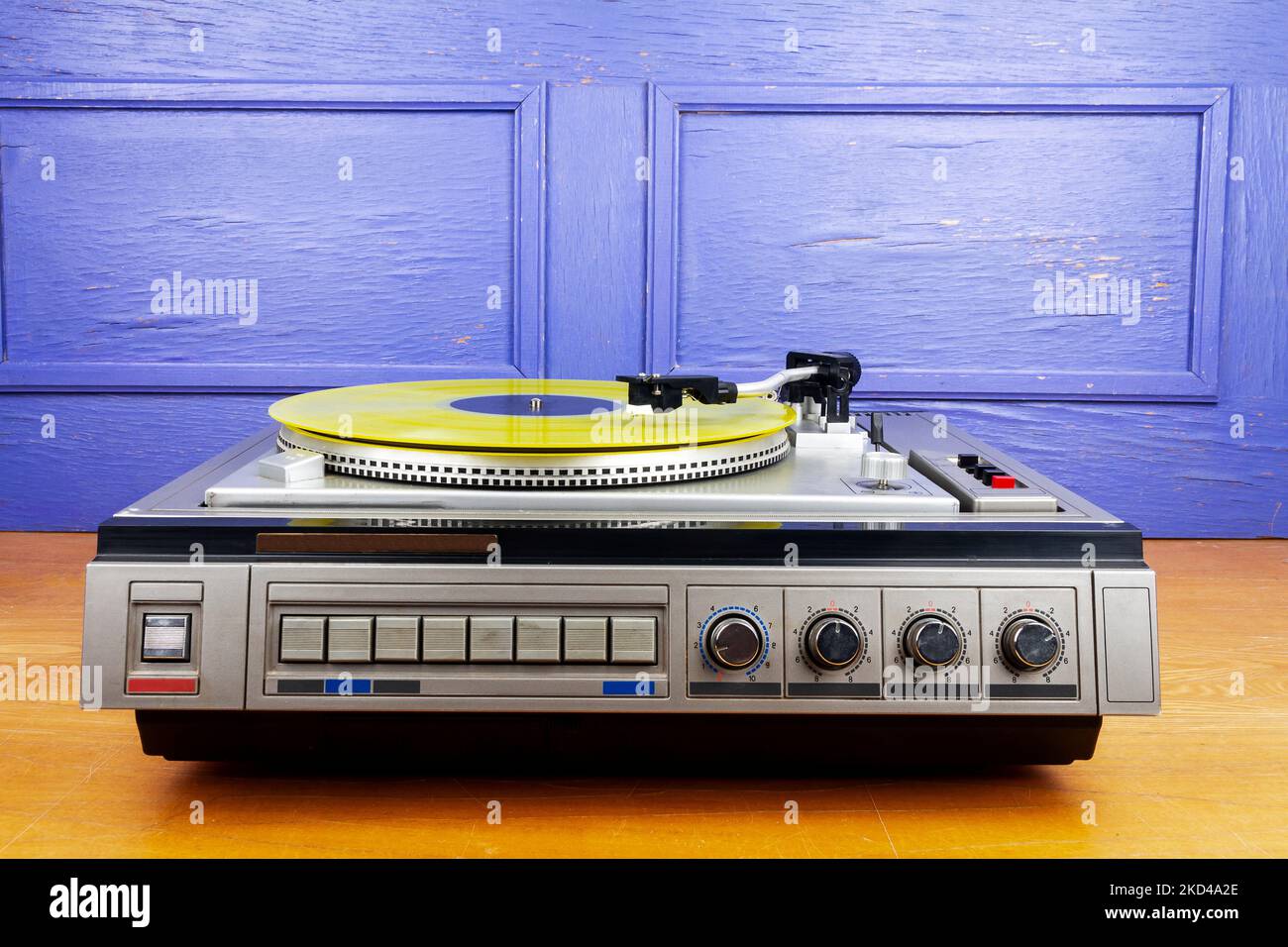 Vintage turntable vinyl record player with yellow vinyl on a table ...