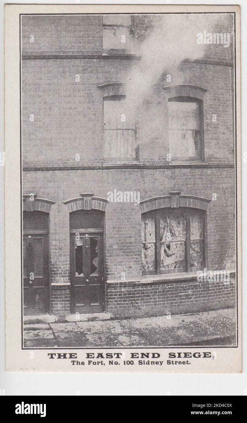 'The East End Siege, The Fort, No. 100 Sidney Street': postcard of the 1911 Siege of Sidney Street, showing 100 Sidney Street with a smashed door and windows, with smoke coming from an upper floor window Stock Photo