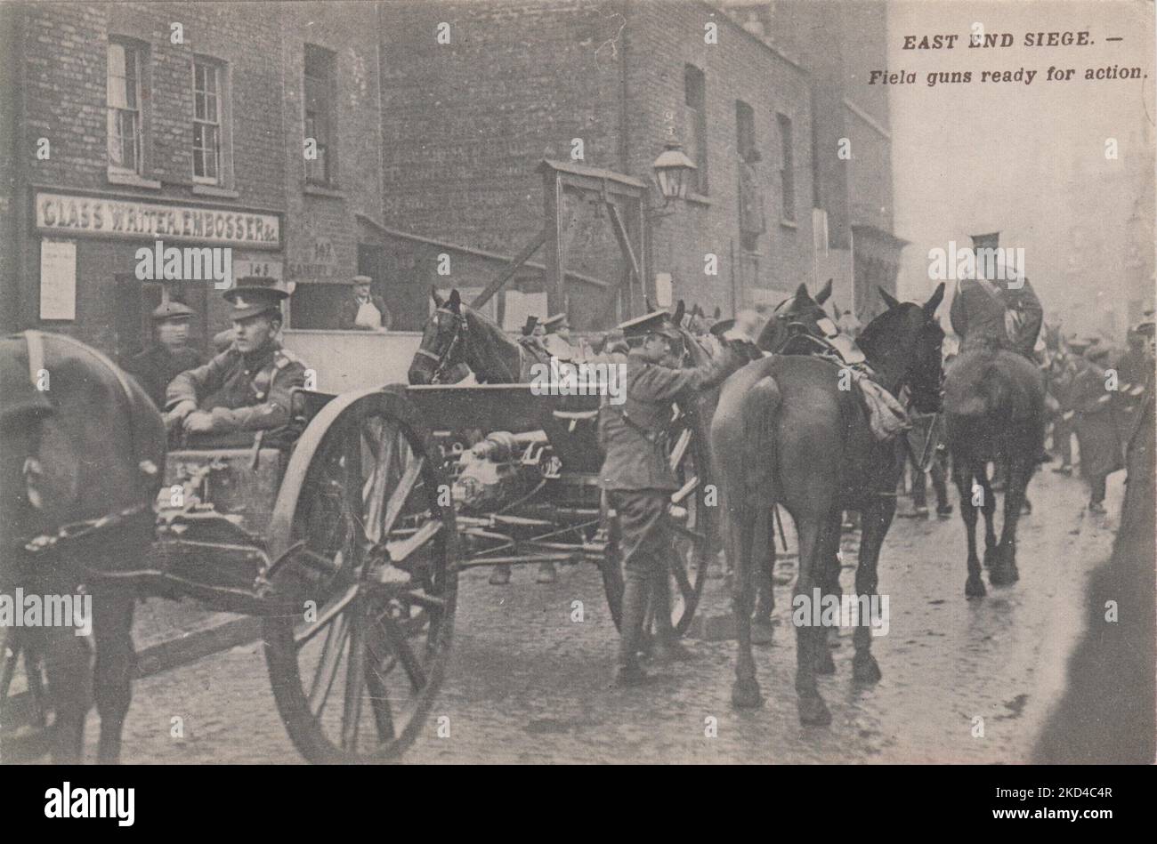 'East End Siege. - Field guns ready for action': postcard of the 1911 Siege of Sidney Street, showing field guns loaded on to horse drawn carriages, other soldiers and army horses are next to them. Several curious onlookers can be seen in the background Stock Photo