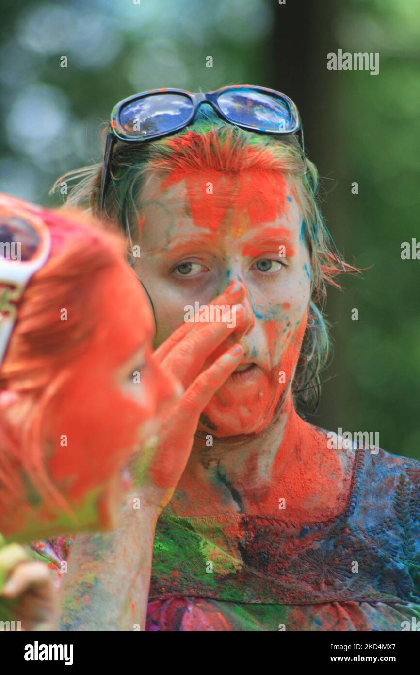Caucasian youth covered in colour celebrate during the Hindu festival