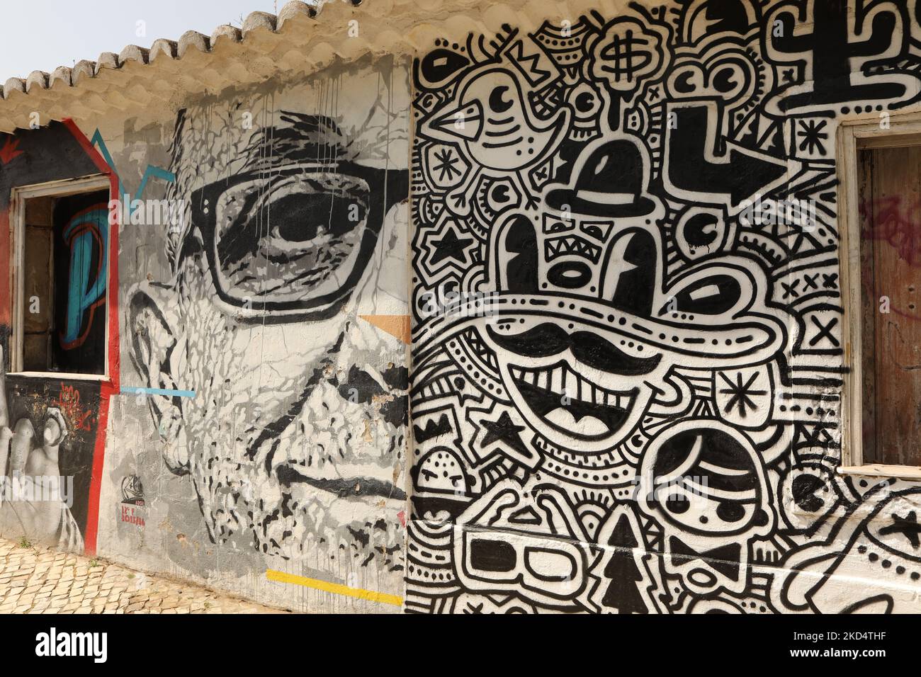 Street Art. A mural of a man wearing spectacles and a pop art mural. Lagos, Algarve, Portugal Stock Photo
