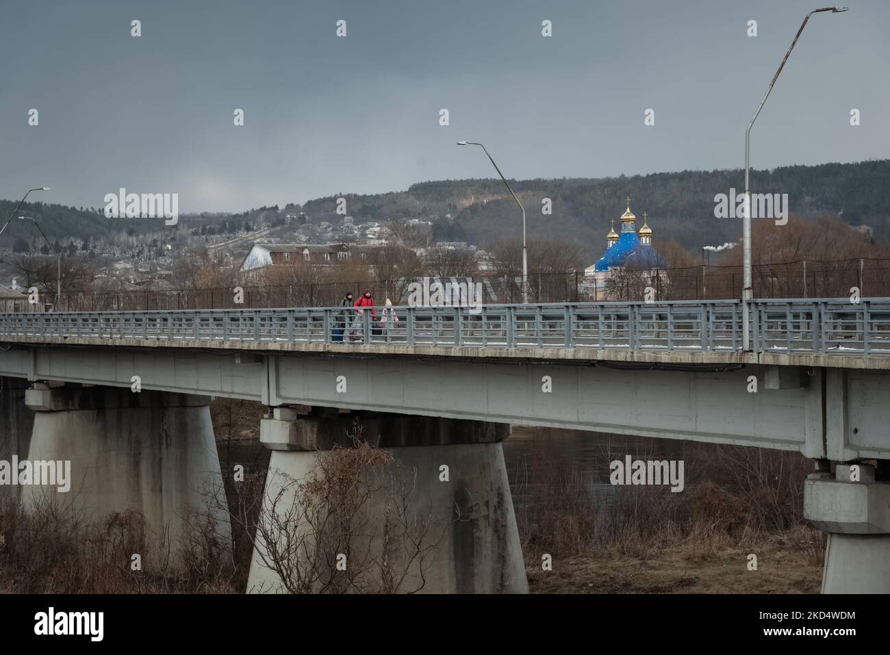 An Ukrainian family of three is seen crossing the Moldovan border through the bridge on the Dnestr river, to reach the city of Otaci, north Moldova, on 2022-03-10. (Photo by Matteo Placucci/NurPhoto) Stock Photo