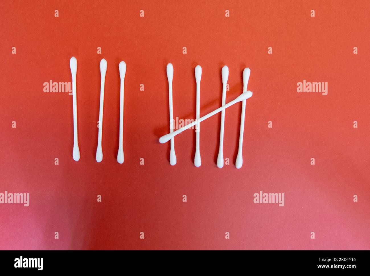 the number eight (8) in Tally marks or hash marks with clean white cotton buds isolated on a dark red background Stock Photo