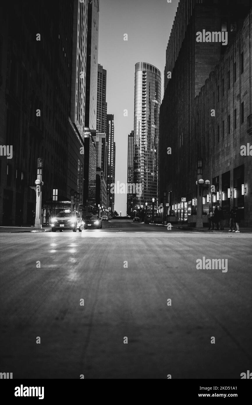 A grayscale shot of Chicago downtown with cars passing with skyscrapers
