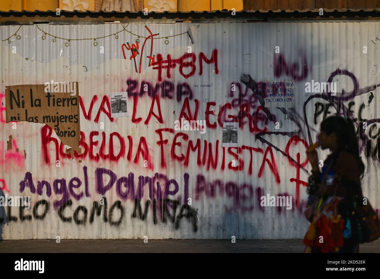 Young woman walks past a graffiti related to the feminist movement on a wall in the center of San Cristobal de las Casas. On Saturday, March 12, 2022, in San Cristobal de las Casas, Chiapas, Mexico. (Photo by Artur Widak/NurPhoto) Stock Photo