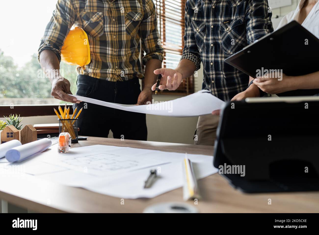 Architect man working with blueprints for architectural plan, engineer sketching a construction