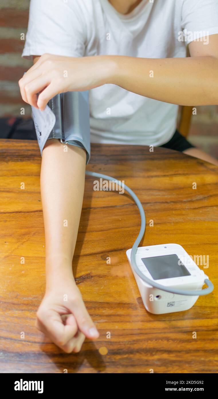 young woman measuring blood pressure and heart rate at home Stock Photo