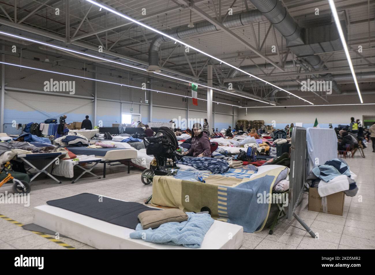 Temporary sleeping area with camp beds and mattresses for people at the