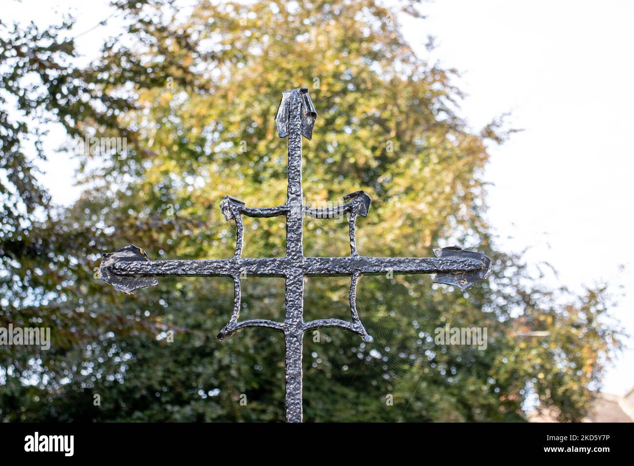 TER, DEVON, UK - SEPTEMBER 20, 2022 Exeter Cathedral - iron cross outside the Cathedral with trees in the background Stock Photo