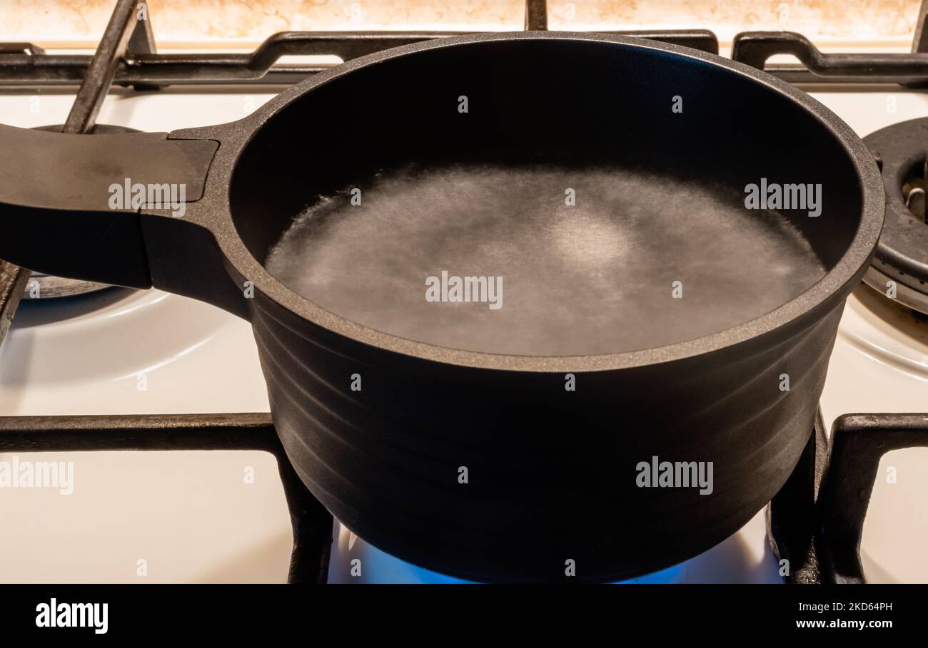 Blurred motion image of boiling water in black metal pot on gas stove closeup Stock Photo Alamy