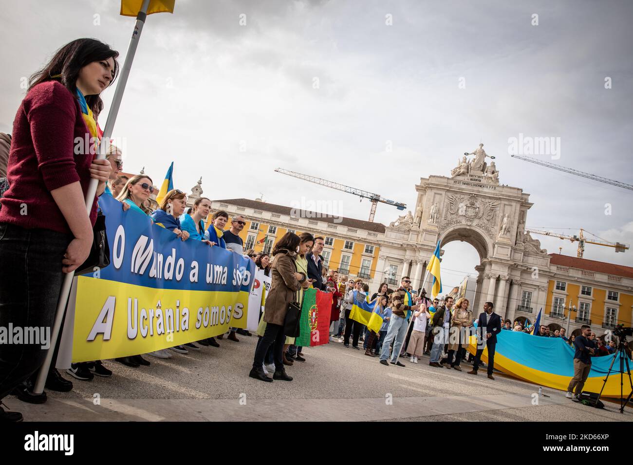People wearing the Ukrainian flag are seen in Praca do Comercio, in Lisbon, Portugal during a demonstration to show solidarity with the people of that country following the Russian invasion on March 27, 2022. - More than 3.8 million people have fled Ukraine since Russia's invasion a month ago, UN figures showed on March 27, but the flow of refugees has slowed down markedly. The UN refugee agency, UNHCR, said 3,821,049 Ukrainians had fled the country -- an increase of 48,450 from the figures of March 26. (Photo by Manuel Romano/NurPhoto) Stock Photo
