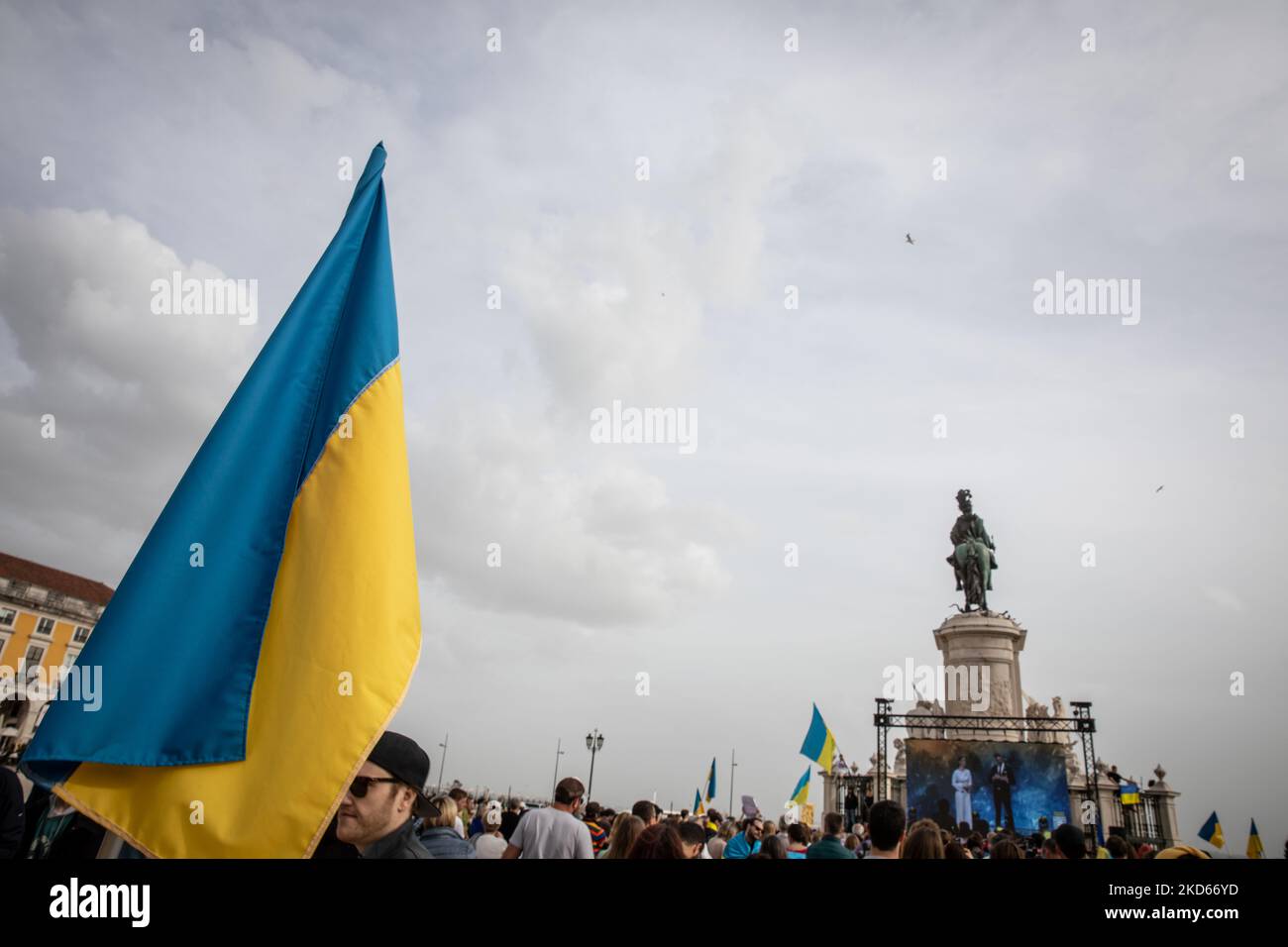 An Ukrainian flag (Ukraine National Flag) is seen in Praca do Comercio, in Lisbon, Portugal during a demonstration to show solidarity with the people of that country following the Russian invasion on March 27, 2022. - More than 3.8 million people have fled Ukraine since Russia's invasion a month ago, UN figures showed on March 27, but the flow of refugees has slowed down markedly. The UN refugee agency, UNHCR, said 3,821,049 Ukrainians had fled the country -- an increase of 48,450 from the figures of March 26. (Photo by Manuel Romano/NurPhoto) Stock Photo