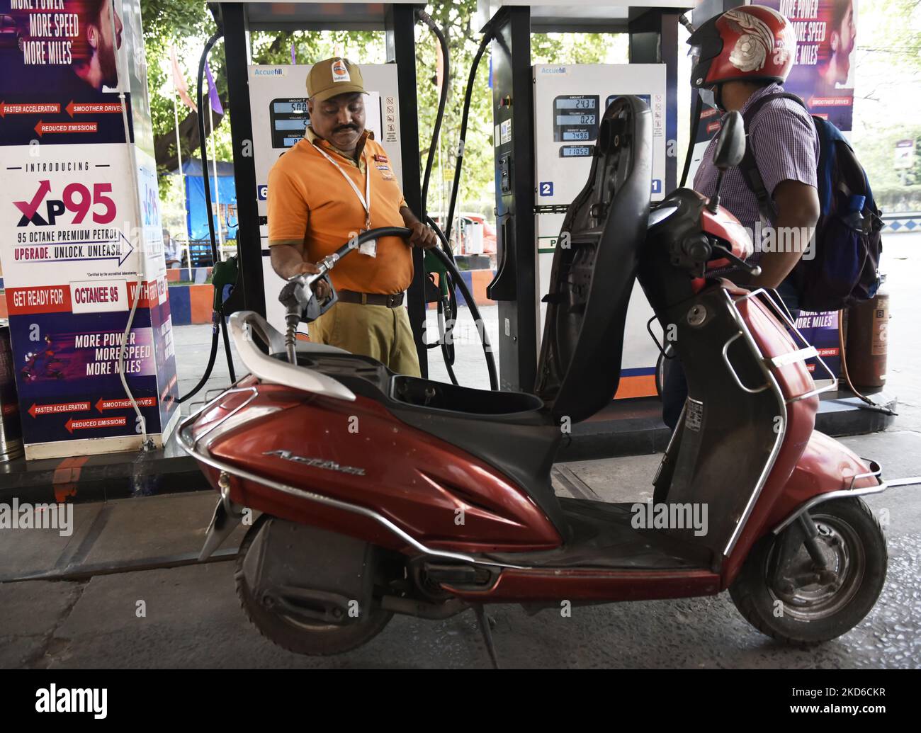 A fuel petrol pump employee puts a nozzle of a scooter in Kolkata