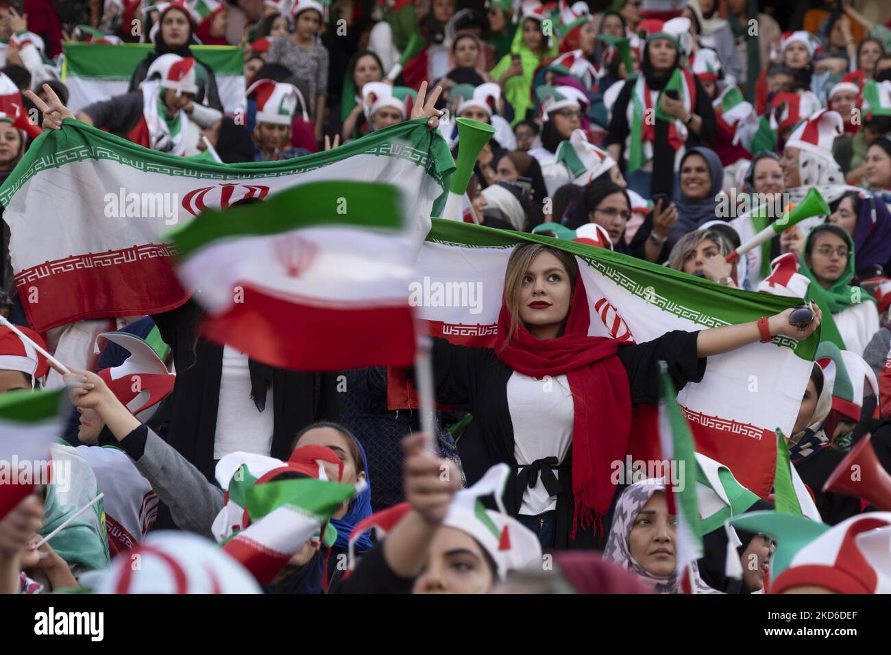 An Iranian soccer female fan holds an Iran flag while attending the