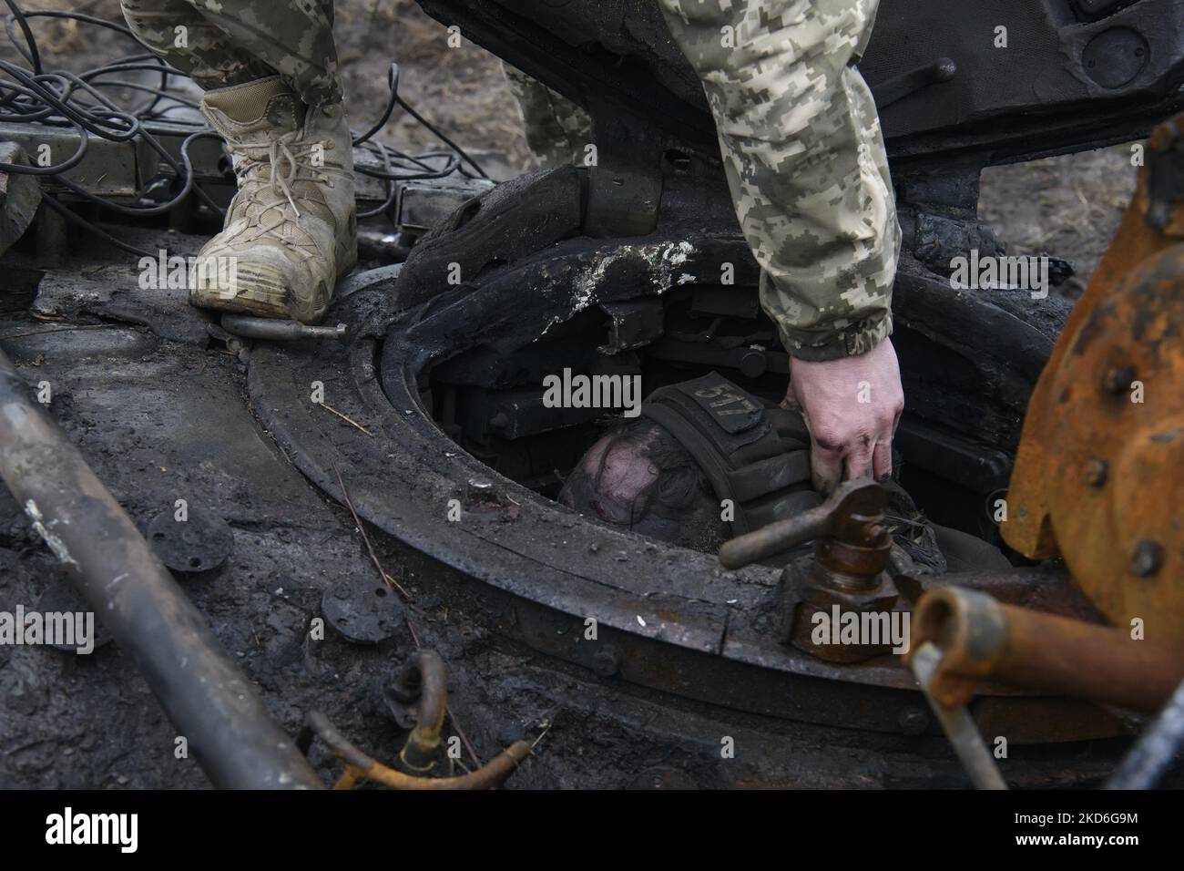 Ukrainian serviceman inspect deceased Russian tankman after Ukrainian Army liberation Dmitrovka village near Kyiv, Ukraine, April 02, 2022. (Photo by Maxym Marusenko/NurPhoto) Stock Photo