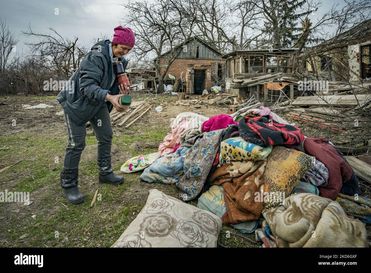 A woman retrieves her belongings from the shelter of her house ...